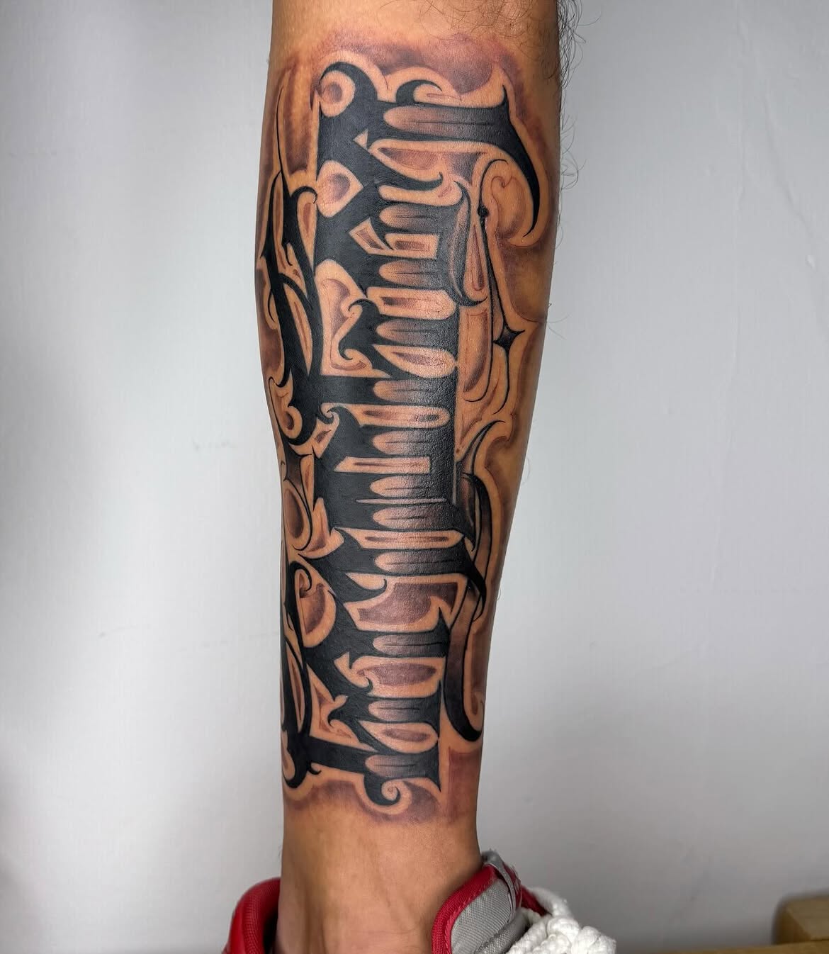 Freehand calligraphy detail by Groc at a Tel Aviv tattoo studio